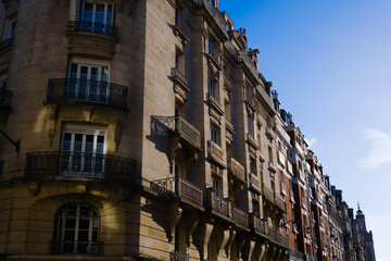 Fototapeta na wymiar Facade illuminated by the golden afternoon sun of neoclassical buildings on the streets of Paris.