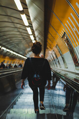 woman seen from behind on a subway escalator