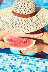 Sexy woman with dark hair eating watermelon