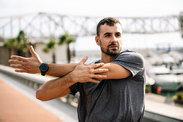 Athlete man stretching before running in the street. Active and sport young male in sportswear...