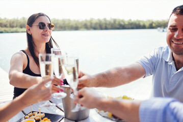 Happy people on the beach having a party, drinking and having a lot of fun in the sunse