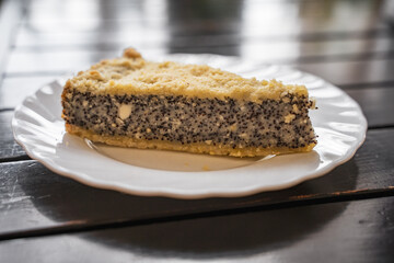 Poppyseed curd pie with a golden crispy crust on a white plate, close-up of a dessert in a restaurant, culinary pastries stand on the table in an establishment