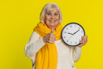 It is your time, hurry up. Senior old woman showing time on wall office clock, ok thumb up approve...