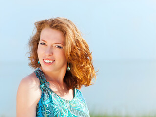 Portrait of the beautiful young woman with fluttering red hair