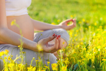 Healthy pregnant woman doing yoga in nature outdoors