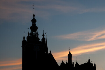 Sylwetka gdańskiego kościoła na tle zachodzącego słońca.
