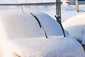 windshield wipers raised up on a snow-covered car. close-up