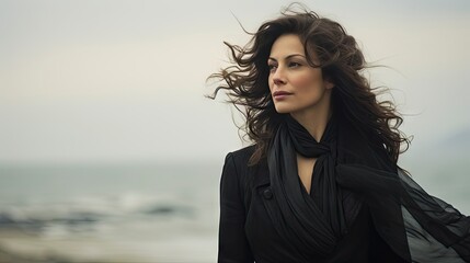 Mystique of the Wind: Elegant Woman with Flowing Hair and Sheer Black Attire Against a Hazy Backdrop.