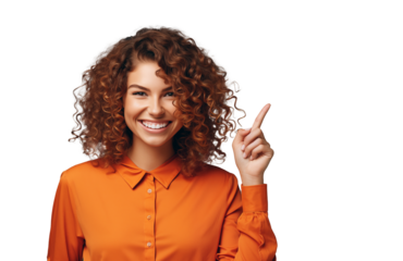 A joyful woman with curly red hair, wearing an orange shirt, happily points upwards to the best offer, discount, interesting or important product. Transparent isolated background.
