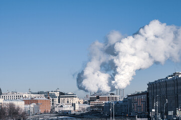 Smoke from cities chimneys in winter on a blue sky background