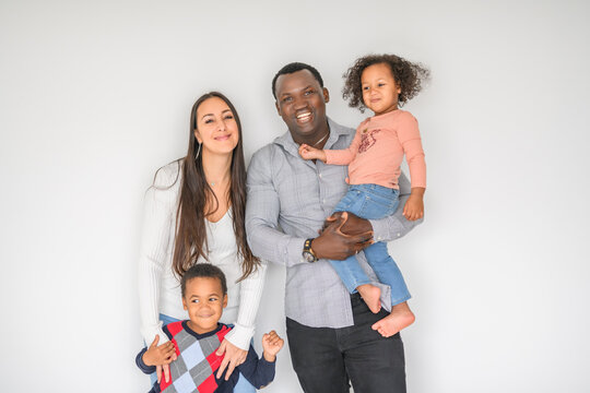 family with boy and girl child posing on photo shooting on white background