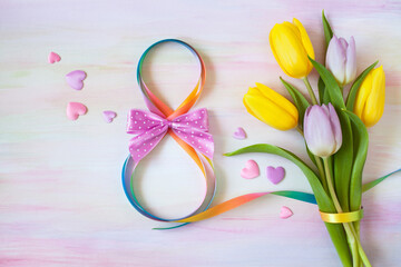 Postcard for Women's Day on March 8, a bouquet of tulips and a ribbon in the shape of a figure eight.