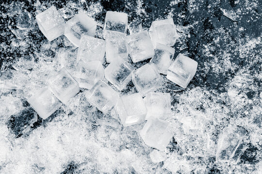 A heap of crushed ice cubes on a black background.