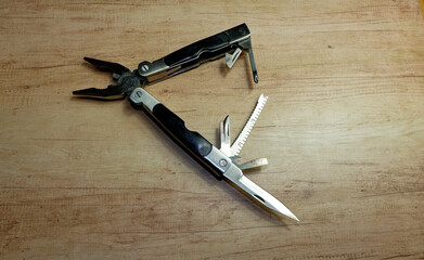 Multitool with scissors, pliers, saw and screwdrivers, isolated with copyspace