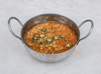 Daal Mash Fry or dal maash fried lentil with green chilli served in karahi isolated on grey background side view of pakistani breakfast and indian spices food - obrazy, fototapety, plakaty