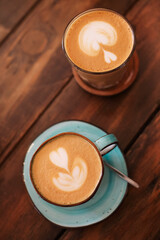 Mugs with latte on wooden table