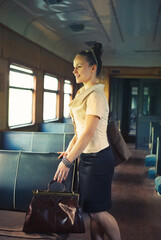 Woman with a suitcase walking in the retro train