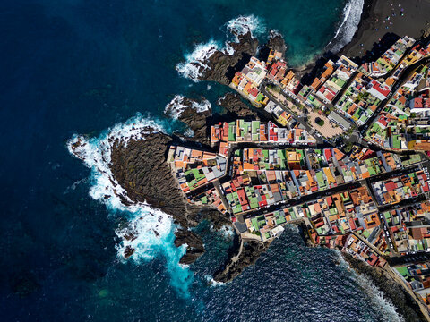 Aerial view of Punta Brava in Tenerife, Canary Island, Spain. Colorful houses and black lava rocks in a small fisherman village. Island in the Atlantic ocean.