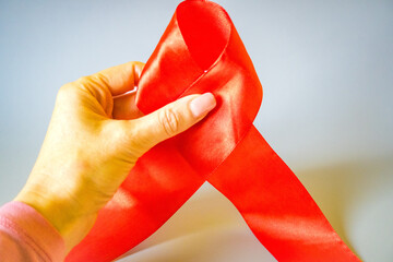 Close up focus on red ribbon in female hands, annual regular health check up