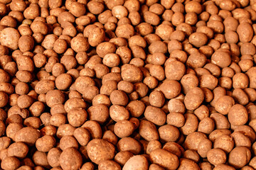 many raw potatoes covered in Prince Edward Island red dirt sitting in a storage warehouse 