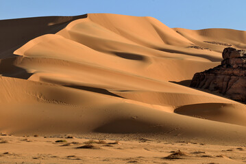 SAHARA DESERT IN ALGERIA. SAND DUNES AND ROCK FORMATIONS AROUND THE OASIS OF DJANET
