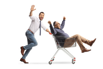 Excited man running and pushing a mature man in a shopping cart