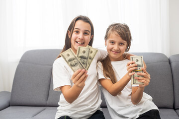 Portrait of two business children with US Dollars as symbol of bribe in an envelope.