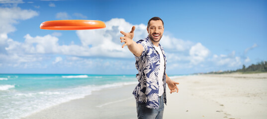Young man throwing a flying disk on a sandy beach