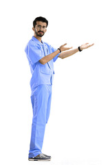 The male doctor, on a white background, in full height, points to the side