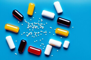 Colorful pills on blue background. Top view with copy space.