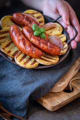 grilled sausages with potatoes on a plate