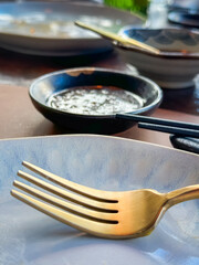 golden metalic fork on ceramic plate on the dining table