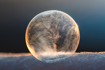 Zamrożona bańka mydlana na śniegu zimą podczas zachodu słońca