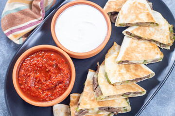 Fajita quesadilla with pieces of beef steak, green bell pepper, onion and cheese, top view