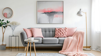 Grey sofa with pink pillows and blanket against white wall with abstract art poster. Interior design of modern living room