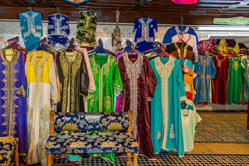 Morocco, row of typical colourful womens embroidered djellaba tunics for sale.
