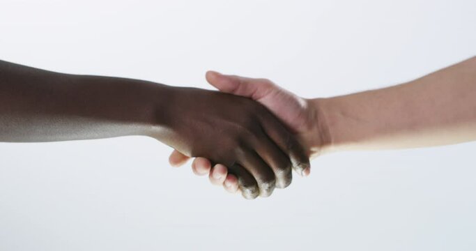 People, interracial and handshake for partnership, thank you or welcome on a gray background. Closeup of person shaking hands for teamwork, unity or greeting together in collaboration on mockup space