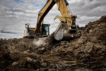Excavator digging into the ground with its large bucket