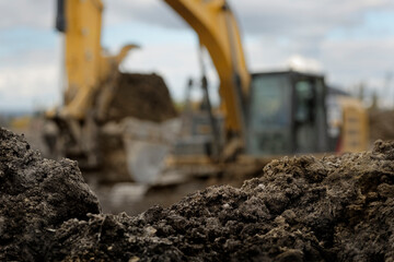 an excavator moving dirt in a construction yard