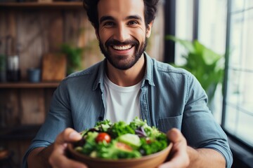 Beautiful man eating healthy salad in the kitchen
