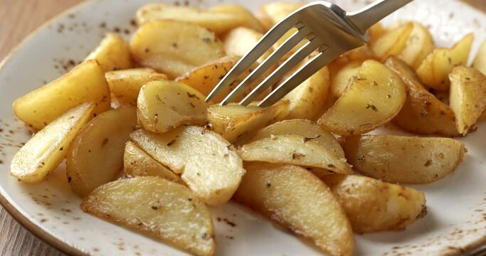 Eating fried potatoes with a fork, close-up