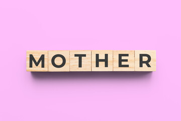 mother wooden cubes on pink background