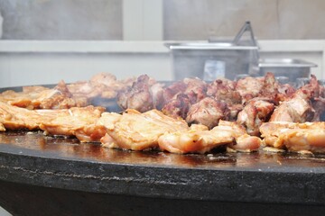 Kebab meat skewers grilling and chicken on fire at backyard. Marinated shashlik, meat grilling on metal skewer. Greek grill food. Outdoor barbecue cooking. Street food concept