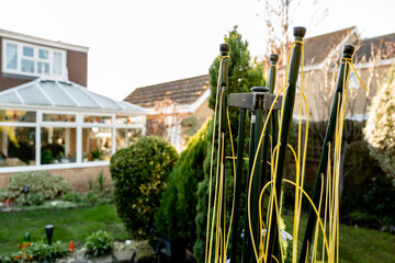 Shallow focus of a folded modern rotary washing line seen in a winter's garden in the morning.