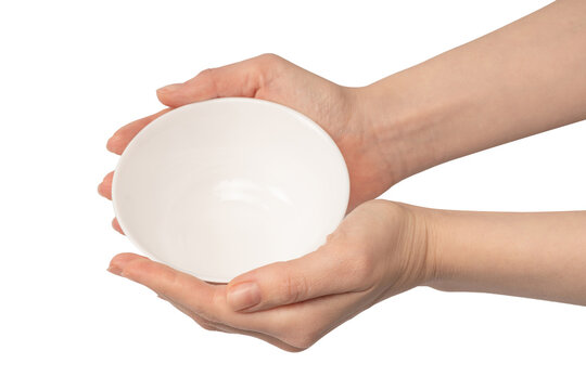 Female hand is holding a ceramic bowl isolated on white background.
