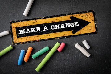 MAKE A CHANGE. Direction arrow with text on a dark chalkboard background