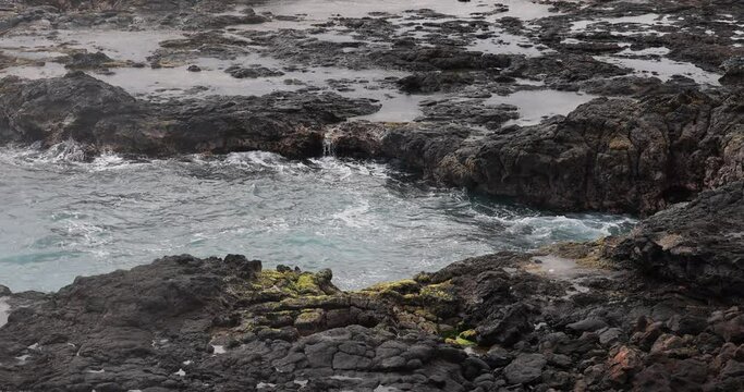 Spouting Horn blow hole wave Kauai Hawaii slow. Crashing ocean surf waves. Tourist Hawaiian seascape recreation. Garden Isle. Volcanic mountain lava rocky coast geology. Pacific ocean.
