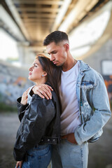 Fototapeta premium fashionable and youthful couple exudes style and love while striking poses on the city streets.