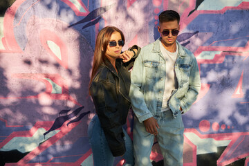 fashionable and youthful couple exudes style and love while striking poses on the city streets.