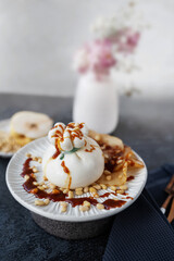 burrata is served with roasted caramelized pear and pine nuts. Close-up.